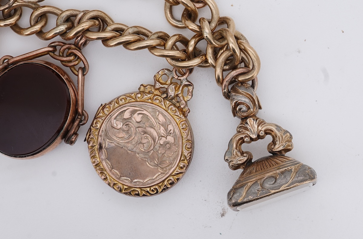 A 1970's 9ct gold curb link charm bracelet, with 9ct gold heart shaped clasp, hung with seven assorted gold or gilt metal mounted charms including six chalcedony set fob seals, gross weight 73 grams.